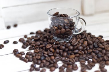 Fincan ve beyaz ahşap arka plan üzerinde kahve tahıl