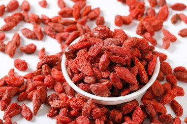 kase ve sağlıklı goji meyveleri beyaz zemin üzerine yığını