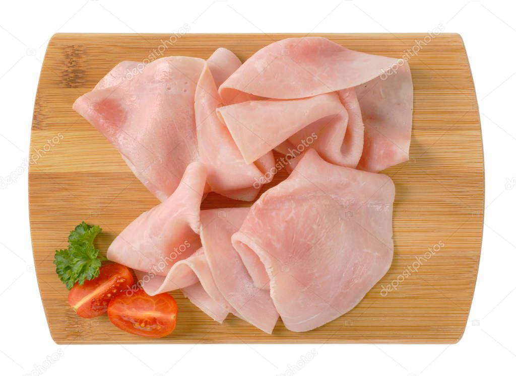 thin slices of pork ham on wooden cutting board