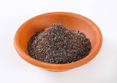 Beyaz arka plan üzerinde zemin haşhaş tohumu kase