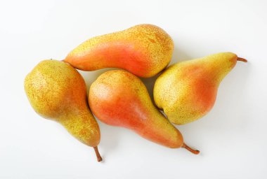 beyaz zemin üzerine dört olgun armut