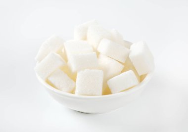 Beyaz arka plan üzerinde beyaz şeker küplerini kase