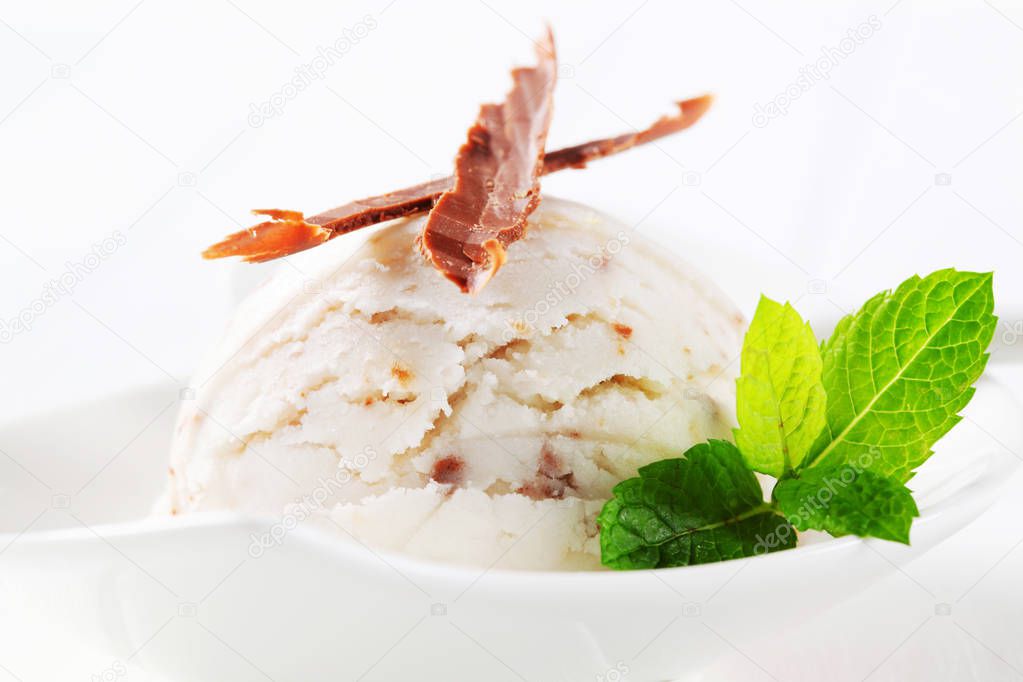 Scoop of stracciatella ice cream topped with chocolate shavings
