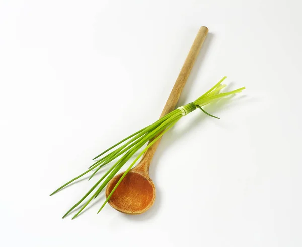 Chives and a wooden spoon — Stock Photo, Image