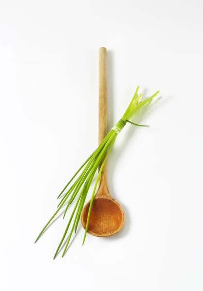 Erba cipollina e un cucchiaio di legno — Foto Stock