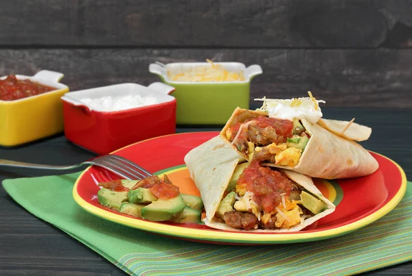 Breakfast Burrito with eggs, chorizo, avocado, cheese and salsa. — Stock Photo, Image