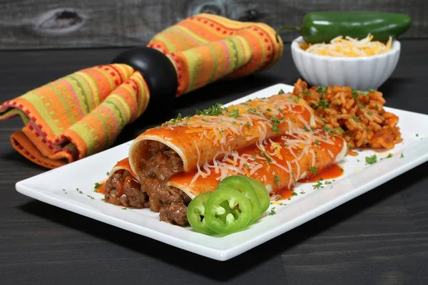 Mexican beef enchiladas on a plate with a serving of Tex Mex rice. Macro view. — Stock Image Mexican Beef Enchiladas Plate Serving Tex Mex Rice Macro View Stock Picture
