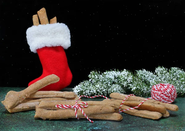 小狗饼干的形状就像圣诞节的包裹棒和节日的长袜 带有复制空间的黑色背景 — 图库照片