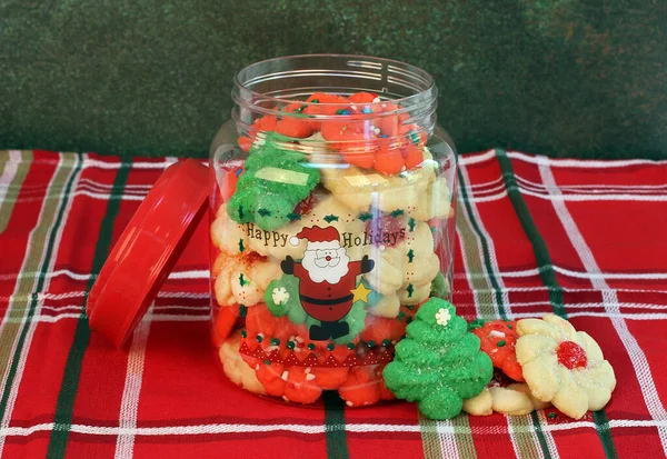 前面放满了圣诞饼干的饼干罐 里面装着圣诞老人和快乐假期 — 图库照片