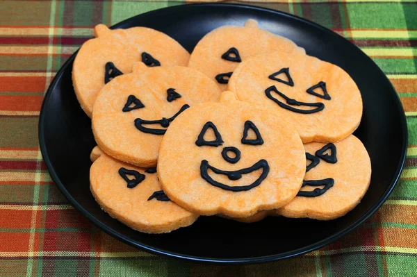 Oranje Pompoen Koekjes Met Gezichten Een Zwarte Plaat Macro Bovenaanzicht — Stockfoto