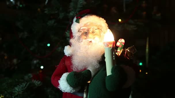 Santa Claus se svíčkou u vánočního stromu 
