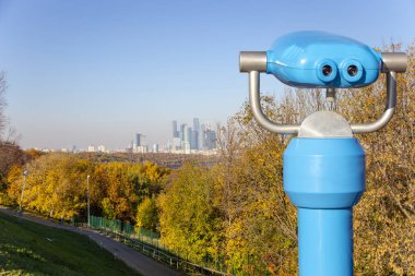 Turistik teleskop Görüntüleyici (dürbün) ve Sparrow Hills veya Vorobyovy Gory gözlem (görüntüleme) platformundan Merkezi Moskova görünümü--, Moskva nehrinin üzerinde dik bir banka 85 m veya deniz seviyesinden 200 m. Moscow, Rusya Federasyonu  