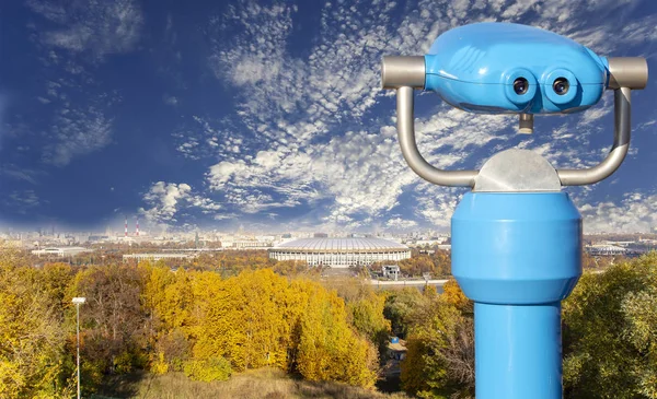 Touristic telescope viewer (binoculars) and view of central Moscow from Sparrow Hills or Vorobyovy Gory observation (viewing) platform-- is on a steep bank 85 m above the Moskva river, or 200 m above sea level. Moscow, Russia