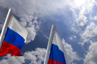 Rusya bayrağı rüzgarda gökyüzüne doğru sallanıyor. Vatansever bir sembol olarak Rus dalgalı bayrağıüç renk 