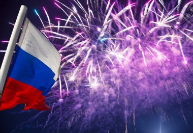 Gökyüzünde patlayan renkli havai fişekler ve rüzgarda gökyüzüne doğru sallanan Rusya bayrağı. Vatansever bir sembol olarak Rus dalgalı bayrağıüç renk  