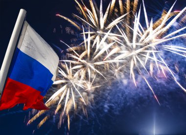 Gökyüzünde patlayan renkli havai fişekler ve rüzgarda gökyüzüne doğru sallanan Rusya bayrağı. Vatansever bir sembol olarak Rus dalgalı bayrağıüç renk  