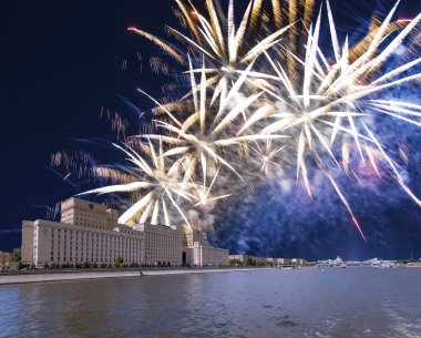 Main Building of the Ministry of Defence of the Russian Federation-- is the governing body of the Russian Armed Forces and celebratory colorful fireworks exploding in the skies. Moscow, Russia   clipart
