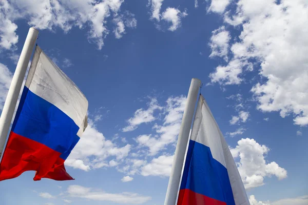 Russia flag waving in the wind against the sky. Three colors of Russian wavy flag as a patriotic symbol