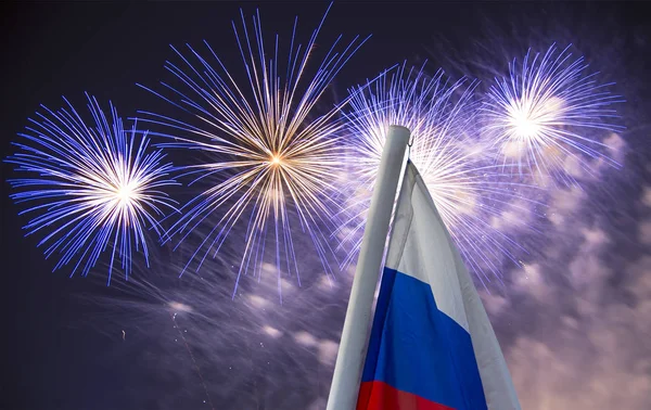 空に爆発するカラフルな花火と 空に向かう風に手を振るロシアの旗 愛国的シンボルとしてのロシアの波状旗の3色 — ストック写真