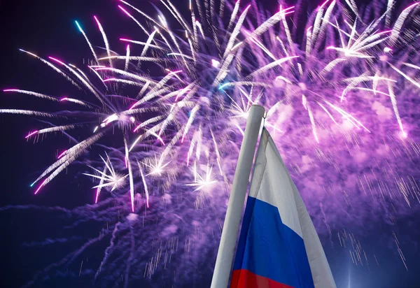 Gökyüzünde patlayan renkli havai fişekler ve rüzgarda gökyüzüne doğru sallanan Rusya bayrağı. Vatansever bir sembol olarak Rus dalgalı bayrağıüç renk  