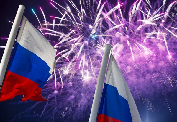 Gökyüzünde patlayan renkli havai fişekler ve rüzgarda gökyüzüne doğru sallanan Rusya bayrağı. Vatansever bir sembol olarak Rus dalgalı bayrağıüç renk  