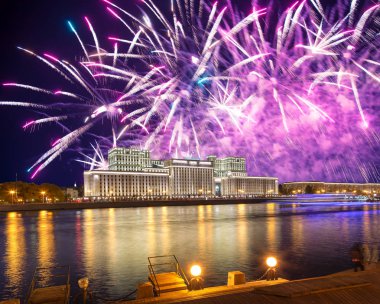 Main Building of the Ministry of Defence of the Russian Federation-- is the governing body of the Russian Armed Forces and celebratory colorful fireworks exploding in the skies. Moscow, Russia clipart