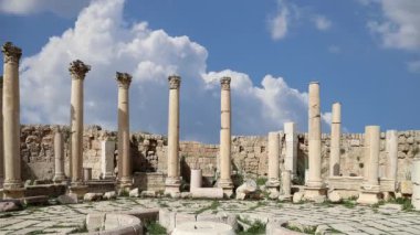 Ürdün 'ün Jerash şehrindeki (Gerasa of Antiquity) Roma harabeleri, hareket eden bulutların arka planına karşı başkent ve en büyük Jerash Valiliği, Ürdün