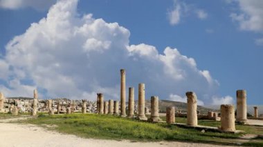 Ürdün 'ün Jerash şehrindeki (Gerasa of Antiquity) Roma harabeleri, hareket eden bulutların arka planına karşı başkent ve en büyük Jerash Valiliği, Ürdün