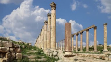 Ürdün 'ün Jerash şehrindeki (Gerasa of Antiquity) Roma harabeleri, hareket eden bulutların arka planına karşı başkent ve en büyük Jerash Valiliği, Ürdün