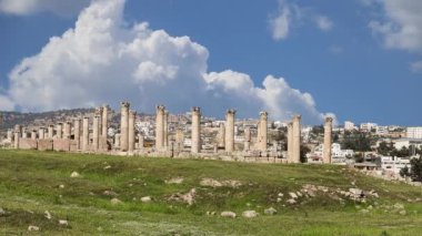 Ürdün 'ün Jerash şehrindeki (Gerasa of Antiquity) Roma harabeleri, hareket eden bulutların arka planına karşı başkent ve en büyük Jerash Valiliği, Ürdün