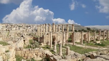 Ürdün 'ün Jerash şehrindeki (Gerasa of Antiquity) Roma harabeleri, hareket eden bulutların arka planına karşı başkent ve en büyük Jerash Valiliği, Ürdün