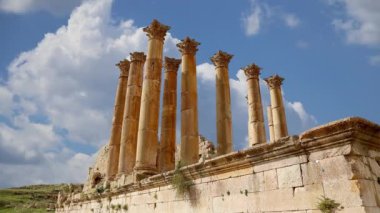 Ürdün 'ün Jerash şehrindeki (Gerasa of Antiquity) Roma harabeleri, hareket eden bulutların arka planına karşı başkent ve en büyük Jerash Valiliği, Ürdün