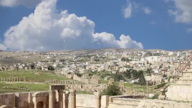 Ürdün 'ün Jerash şehrindeki (Gerasa of Antiquity) Roma harabeleri, hareket eden bulutların arka planına karşı başkent ve en büyük Jerash Valiliği, Ürdün  