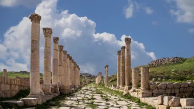 Ürdün 'ün Jerash şehrindeki (Gerasa of Antiquity) Roma harabeleri, hareket eden bulutların arka planına karşı başkent ve en büyük Jerash Valiliği, Ürdün  
