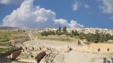 Ürdün, Gerasa 'da (Jerash) hareket eden bulutların arka planına karşı Forum (Oval Plaza). Forum, M.S. 1. yüzyılda inşa edilen Colonnaded Caddesi 'nin başlangıcında asimetrik bir plazadır. 