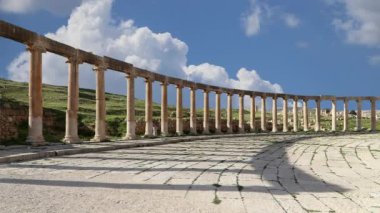 Ürdün, Gerasa 'da (Jerash) hareket eden bulutların arka planına karşı Forum (Oval Plaza). Forum, M.S. 1. yüzyılda inşa edilen Colonnaded Caddesi 'nin başlangıcında asimetrik bir plazadır. 