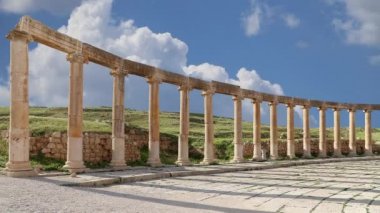 Ürdün, Gerasa 'da (Jerash) hareket eden bulutların arka planına karşı Forum (Oval Plaza). Forum, M.S. 1. yüzyılda inşa edilen Colonnaded Caddesi 'nin başlangıcında asimetrik bir plazadır. 