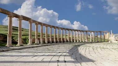Ürdün, Gerasa 'da (Jerash) hareket eden bulutların arka planına karşı Forum (Oval Plaza). Forum, M.S. 1. yüzyılda inşa edilen Colonnaded Caddesi 'nin başlangıcında asimetrik bir plazadır. 