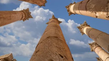 Ürdün 'ün Jerash şehrindeki Roma Sütunları (Antik Gerasa) hareket halindeki bulutların, başkentin ve en büyük Jerash Valiliği kentinin arka planına karşı 