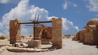 Amman yakınlarındaki Amra Çölündeki Kureyir (Qasr) Çöl Kalesi, hareket eden bulutların arka planına karşı, Ürdün. Ünlü freskleri olan dünya mirası..  