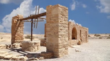Amman yakınlarındaki Amra Çölündeki Kureyir (Qasr) Çöl Kalesi, hareket eden bulutların arka planına karşı, Ürdün. Ünlü freskleri olan dünya mirası..  