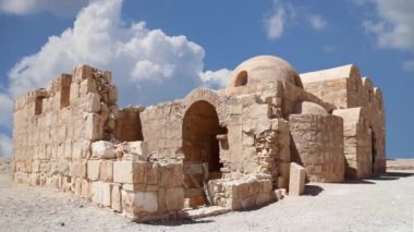 Amman yakınlarındaki Amra Çölündeki Kureyir (Qasr) Çöl Kalesi, hareket eden bulutların arka planına karşı, Ürdün. Ünlü freskleri olan dünya mirası..  