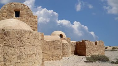 Amman yakınlarındaki Amra Çölündeki Kureyir (Qasr) Çöl Kalesi, hareket eden bulutların arka planına karşı, Ürdün. Ünlü freskleri olan dünya mirası..  