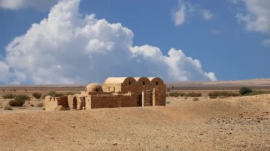 Amman yakınlarındaki Amra Çölündeki Kureyir (Qasr) Çöl Kalesi, hareket eden bulutların arka planına karşı, Ürdün. Ünlü freskleri olan dünya mirası..  