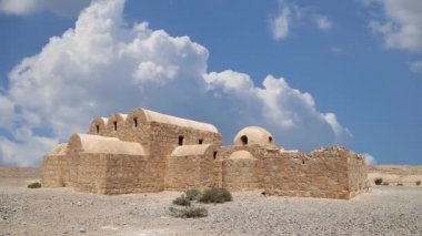 Amman yakınlarındaki Amra Çölündeki Kureyir (Qasr) Çöl Kalesi, hareket eden bulutların arka planına karşı, Ürdün. Ünlü freskleri olan dünya mirası..  