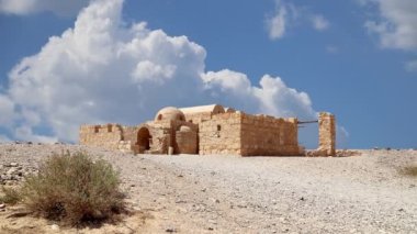 Amman yakınlarındaki Amra Çölündeki Kureyir (Qasr) Çöl Kalesi, hareket eden bulutların arka planına karşı, Ürdün. Ünlü freskleri olan dünya mirası..  