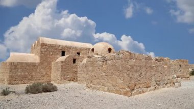 Amman yakınlarındaki Amra Çölündeki Kureyir (Qasr) Çöl Kalesi, hareket eden bulutların arka planına karşı, Ürdün. Ünlü freskleri olan dünya mirası..  