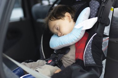 Mutlu Anne oğlunu arabada emniyet kemeri tutturmak için yardım
