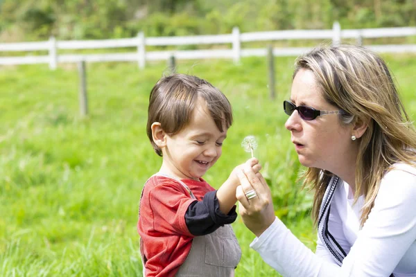 Happy Mother Boy Blowing White Dandelion Outdoors — Stock Photo, Image