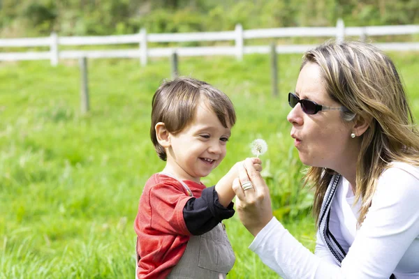 Happy Mother Boy Blowing White Dandelion Outdoors — Stock Photo, Image